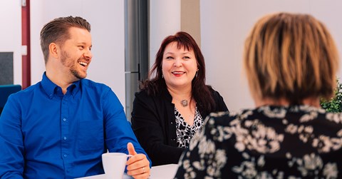 A man and two women are around the table and having a good time.