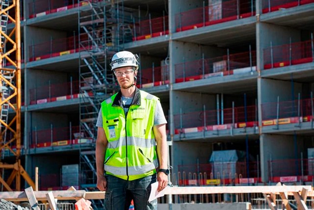 Foreman Juho Peltoniemi stands in front of the Karjasilta Corner under construction. 