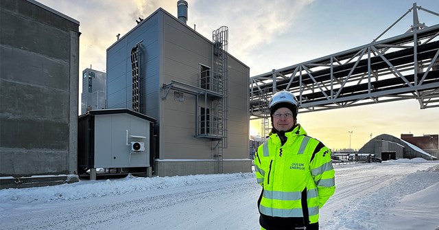 Polttoainehankinnoista vastaava Lauri Heilala seisoo ja hymyilee Sähkökattila hänen selkänsä takana.