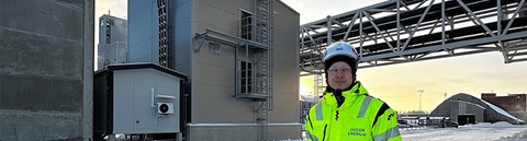 Oulun Energian työntekijä seisoo Laanilan sähkökattilan edessä. 